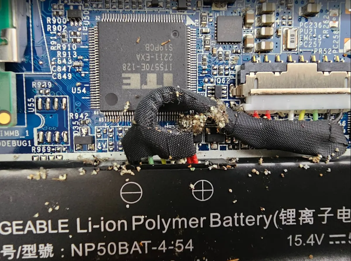 筆電內部硬碟與主機板上堆積白色異物的實體照片｜台中逢甲筆電維修 維修照片 2
